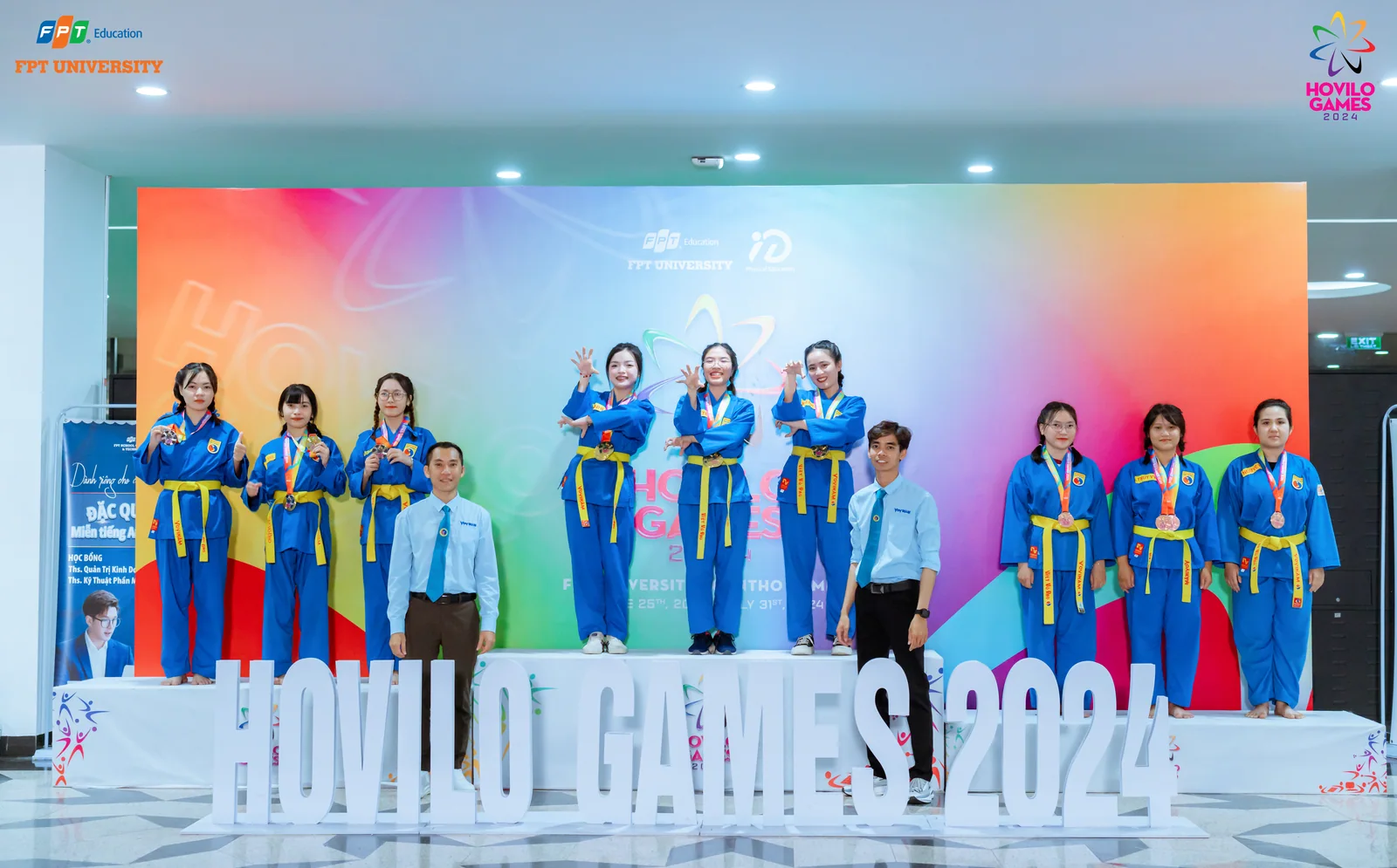 Nhóm võ sinh đứng trên sân khấu dưới ánh đèn