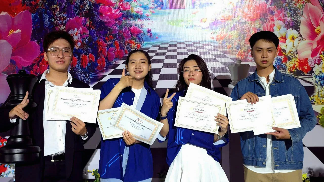 Bốn người bạn cùng cầm giấy chứng nhận trước phông sân khấu