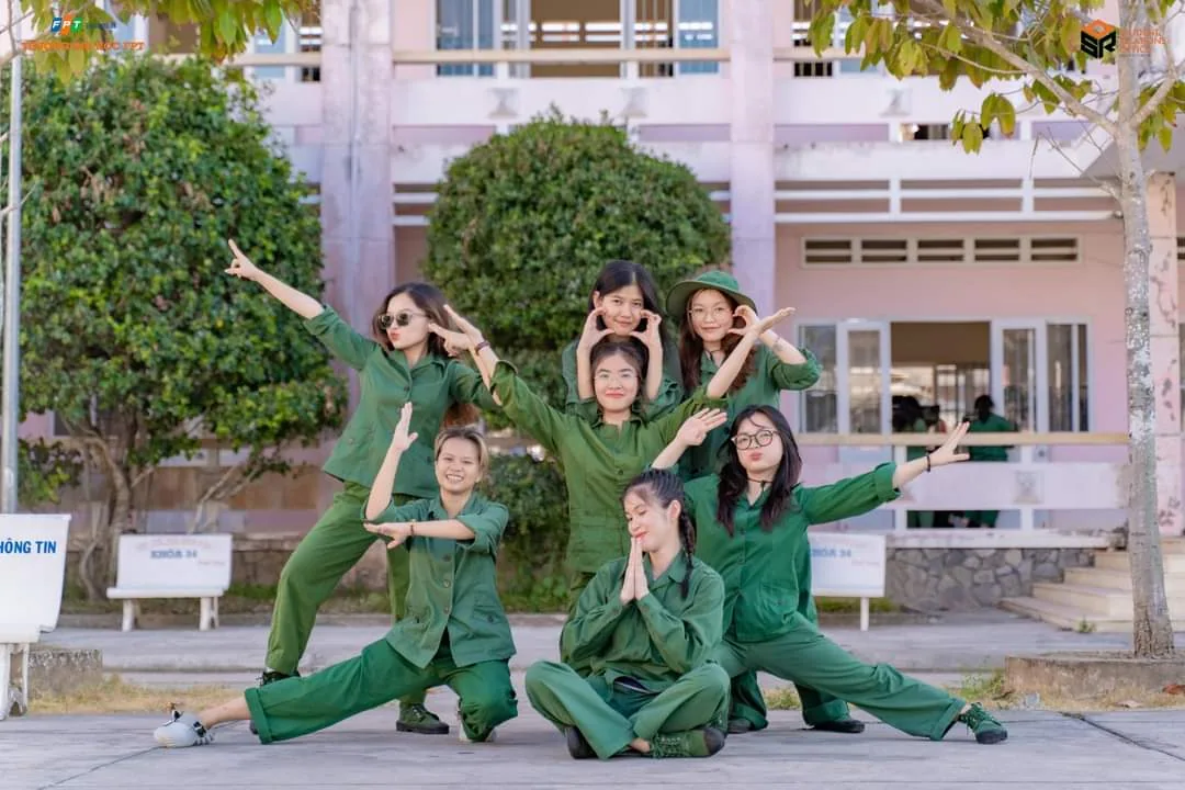 Nhóm bạn mặc quân phục xanh tạo dáng ngoài sân